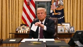 Donald Trump tient une lettre laissée par Joe Biden dans le Bureau ovale, le 20 janvier 2025 à la Maison Blanche