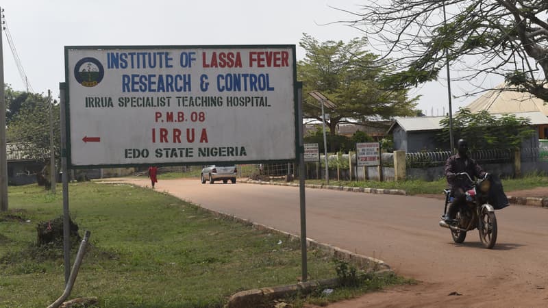 Un motocycliste passe devant un panneau de signalisation indiquant l'Institut de recherche et de contrôle de la fièvre de Lassa à l'hôpital universitaire spécialisé d'Irrua, à Irrua, dans l'État d'Edo, dans le Midwest du Nigeria, le 6 mars 2018.