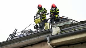 Des pompiers sur le bâtiment où s'est déclaré dans la nuit un incendie mortel à Neuves-Maisons, en Meurthe-et-Moselle, le 30 novembre 2025