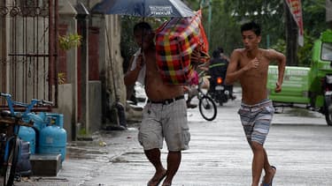 Des habitants mettent leurs biens à l'abri avant l'arrivée du typhon Mangkhut, le 14 septembre.