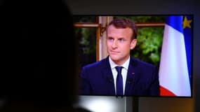 Une femme regarde Emmanuel Macron lors d'un entretien télévisé, à Rennes, le 15 octobre 2017