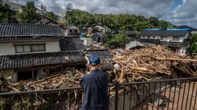 Un homme devant les dégâts causés par les inondations, le long de la rivière Tsukada à la suite de fortes pluies dans la ville de Wajima, le 23 septembre 2024.