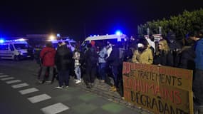 Des membres d'associations de défense des migrants se rassemblent à côté d'une pancarte indiquant « 30 ans d'annonces, de traitements inhumains et dégradants » le 24 novembre 2021 à Calais, dans le nord de la France, suite au naufrage d'un bateau de migrants traversant la Manche vers l'Angleterre. (Photo d'illustration)