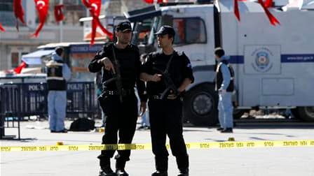Enquêteurs sur la place Taksim, un lieu très fréquenté d'Istanbul, après une explosion visant une voiture de police. Cette explosion, provoquée selon la police par un kamikaze, a blessé 22 personnes (dix policiers et 12 civils). /Photo prise le 31 octobre