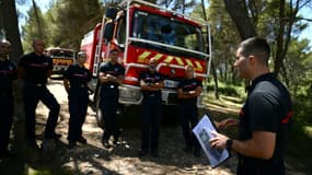 Des pompiers écoutent les instructions dans une forêt de Gardanne, le 25 juillet 2023 dans les Bouches-du-Rhône