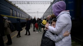 Une femme étreint un enfant avant le départ d'un train de la gare de Zaporijia dans le sud de l'Ukraine le 17 avril 2022