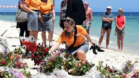 Des touristes participent à une cérémonie en l'hommage des victimes de l'attentat de Sousse en Tunisie