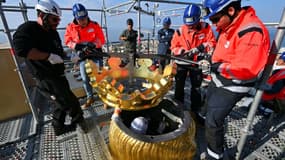 Des ouvriers remettent en place la couronne dorée de la statue de la Bonne Mère, à Marseille, le 17 octobre 2025