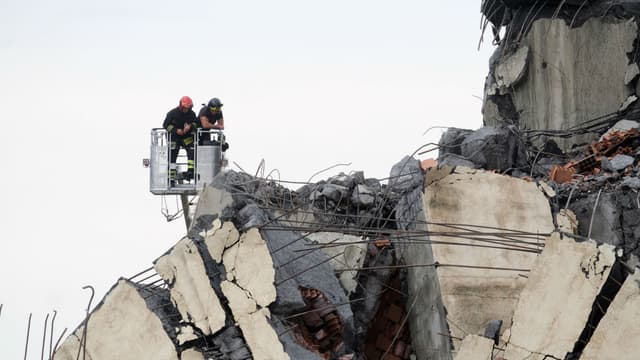 Les secouristes reconnaissent les décombres du viaduc Morandi.