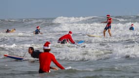 Des surfeurs déguisés en Père Noël à Cocoa Beach, en Floride, le 24 décembre 2023.