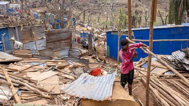 Un homme travaille à la reconstruction d'une maison détruite dans la ville de Vahibe, à la périphérie de Mamoudzou, à Mayotte, le 24 décembre 2024.