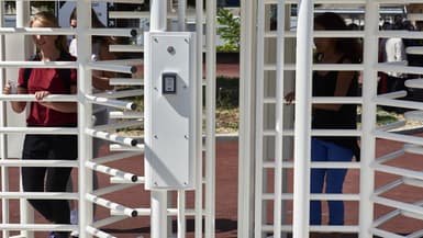 Des lycéens franchissent une barrière de sécurité récemment installée à l'entrée du lycée "Galilée" à Vienne, dans le sud-est de la France, le 1er septembre 2016.