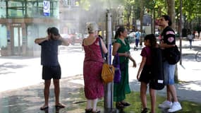 Des personnes se rafraîchissent lors d'une vague de chaleur, le 21 juin 2025 à Paris