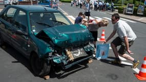 Des automobilistes observent une reconstitution d'accident présentée par des sapeurs pompiers le 29 juin 2012 à Mâcon.