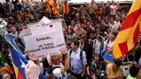 Deux manifestants portent une fausse urne, lors d'un rassemblement à Barcelone, le 20 septembre 2017.