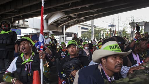 Des manifestants anti-gouvernement derrière une barricade, à Bangkok./