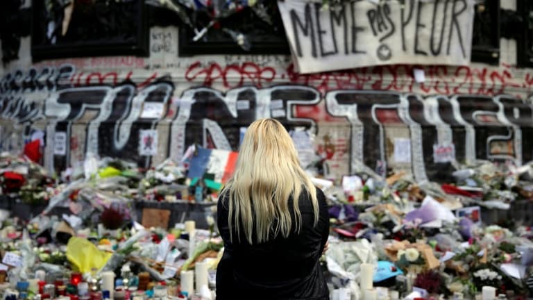 Une femme se recueille devant un mémorial improvisé composé de fleurs, de bougies et de messages, place de la République à Paris, le 17 novembre 2015, en hommage aux victimes des attentats du 13 novembre 2015