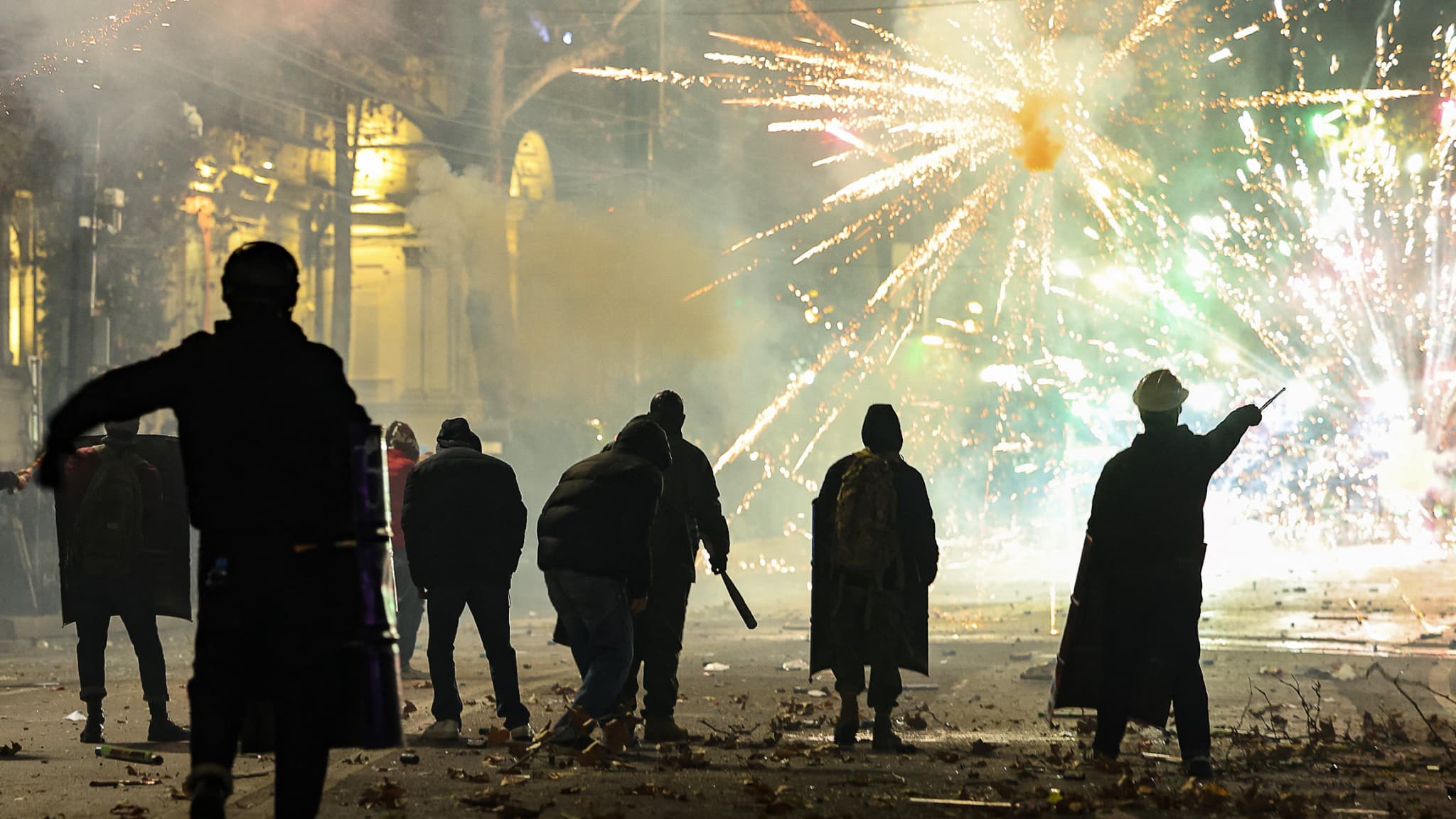 Des manifestants se tiennent au milieu d'explosions de feux d'artifice et se heurtent à la police dans le centre de Tbilissi, le 4 décembre 2024.