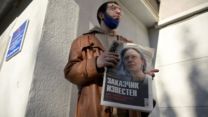 Un homme tient un journal avec la photo de la journaliste d'investigation Anna Politkovskaya près du bureau du journal Novaïa Gazeta à Moscou, le 7 octobre 2021. 