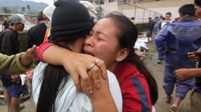 Proches de victimes d'inondations éclair à New Bataan dans la province de Compostela, dans le sud des Philippines. Le typhon Bopha qui frappe l'archipel a fait au moins 283 morts et des centaines de disparus sur l'île de Mindanao. /Photo prise le 5 décemb