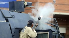 Un policier vénézuélien tire une bombe de gaz lacrymogène, le 22 mars 2014.