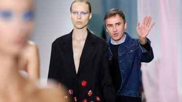 Raf Simons salue le public à la fin du défilé printemps-été 2013 de Dior, le 28 septembre