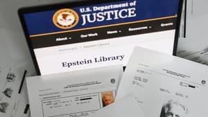 Des documents imprimés disponibles à la bibliothèque Epstein sur le site du ministère américain de la Justice affichés devant un écran d'ordinateur portable, dans une photographie prise à Cracovie (Pologne) le 17 février 2026.