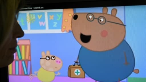 Une passante à Londres devant un écran montrant un épisode du dessin animé britannique "Peppa Pig", le 12 décembre 2017