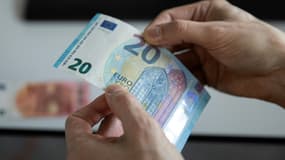 Eric Languillat, l'un des experts du laboratoire anti-contrefaçons de la Banque centrale européenne, vérifie un billet de 20 euros, le 22 décembre 2021 à Francfort, en Allemagne