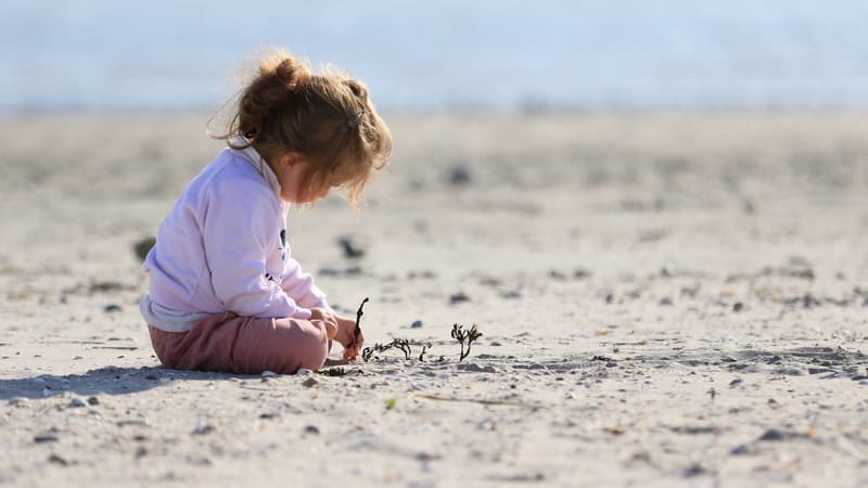 Une enfant jouant sur une plage (Photo d'illustration)