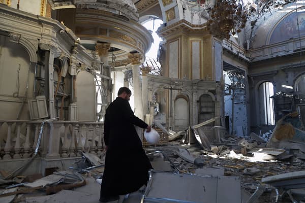 Un prêtre examine les dégâts après la destruction de la cathédrale de la Transfiguration à la suite d'un tir de missile à Odessa, en juillet 2023.