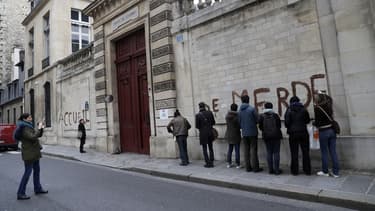 Les mains recouvertes de gants en latex, chacun des militants a dessiné une lettre en capitale sur le mur de pierre