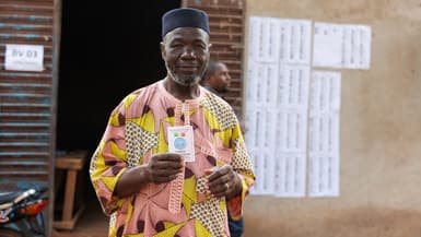 Un électeur montre sa carte après avoir voté pour le référendum sur la nouvelle Constitution à Bamako, au Mali, le 18 juin 2023