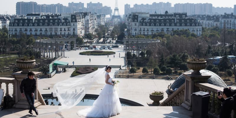 Un couple de mariés chinois pose devant la réplique de la tour Eiffel de Tianducheng le 26 janvier 2016