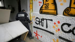 Un policier de la 14e Brigade BST recherche de la drogue dans un point de deal de la cité des Rosiers, dans les quartiers nord de Marseille, le 1er décembre 2023