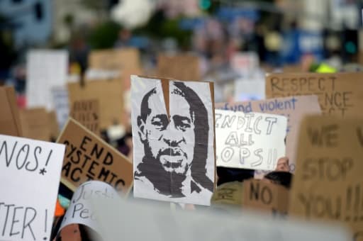 Des manifestants brandissent un portrait de George Floyd lors d'un rassemblement pour dénoncer le racisme et les violences policières, à Hollywood, le 7 juin 2020 Des manifestants brandissent un portrait de George Floyd lors d'un rassemblement pour dénoncer le racisme et les violences policières, à Hollywood, le 7 juin 2020