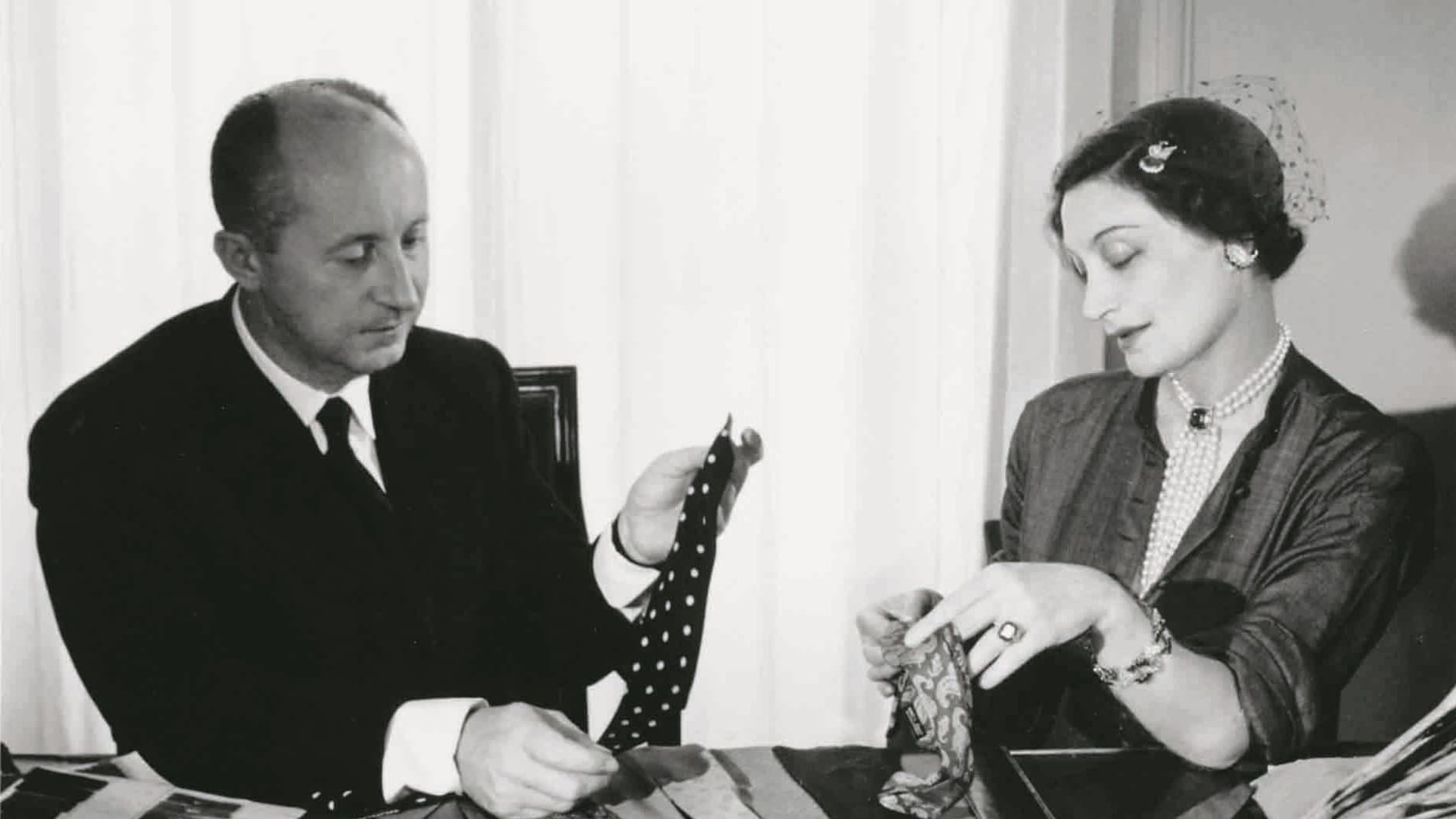 Christian Dior examinant des cravates avec Mizza Bricard,vers 1950. Association Willy Maywald – Adagp, Paris, 2024 – DACS, Londres, 2018. Ed La Martinière