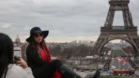 Une touriste pose devant la tour Eiffel, le 31 décembre 2017
