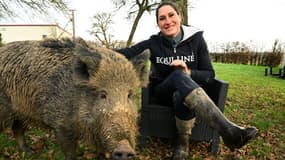 Élodie Cappe, éleveuse de chevaux française, pose avec un sanglier domestique baptisé « Rillette » qu'elle a recueilli et domestiqué en France depuis plus d'un an à Chaource, le 24 décembre 2024.