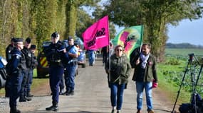 Des militants opposés aux "bassines" passent devant des gendarmes, près du chantier de construction d'une nouvelle réserve d'eau pour l'irrigation agricole à Sainte-Soline, le 2 novembre 2022 dans les Deux-Sèvres.