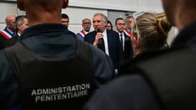 François Bayrou, flanqué du ministre français de l'Intérieur Bruno Retailleau (2e à droite), s'adresse aux membres du personnel de l'administration pénitentiaire lors de sa visite du centre pénitentiaire de Saint-Quentin-Fallavier, dans le sud-est de la France, le 23 avril 2025, au lendemain de plusieurs attaques contre les infrastructures et le personnel pénitentiaires à travers le pays ces dernières semaines.