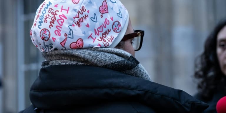 L'infirmière Majdouline, révoquée de la fonction publique pour avoir pour avoir refusé de manière répétée d'ôter son calot chirurgical, s'adresse aux journalistes devant le tribunal administratif de Paris, le 23 décembre 2025