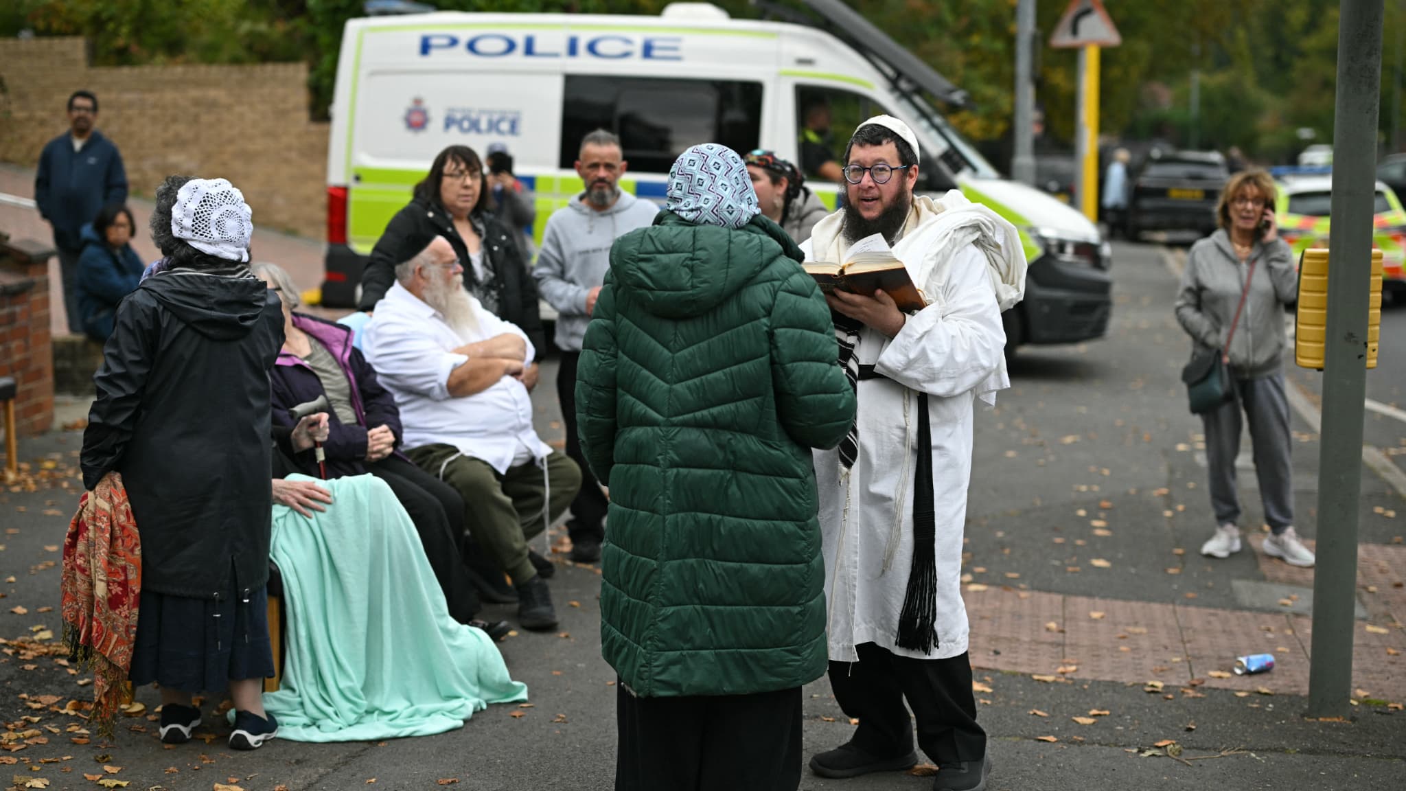 Members of the local Jewish community in front of a synagogue in northern Manchester, England on October 2, 2025.
