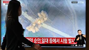 Une femme à Séoul marche devant un écran de télévision montrant le lancement d'un missile balistique sur une chaîne d'actualité, le 5 juin 2022