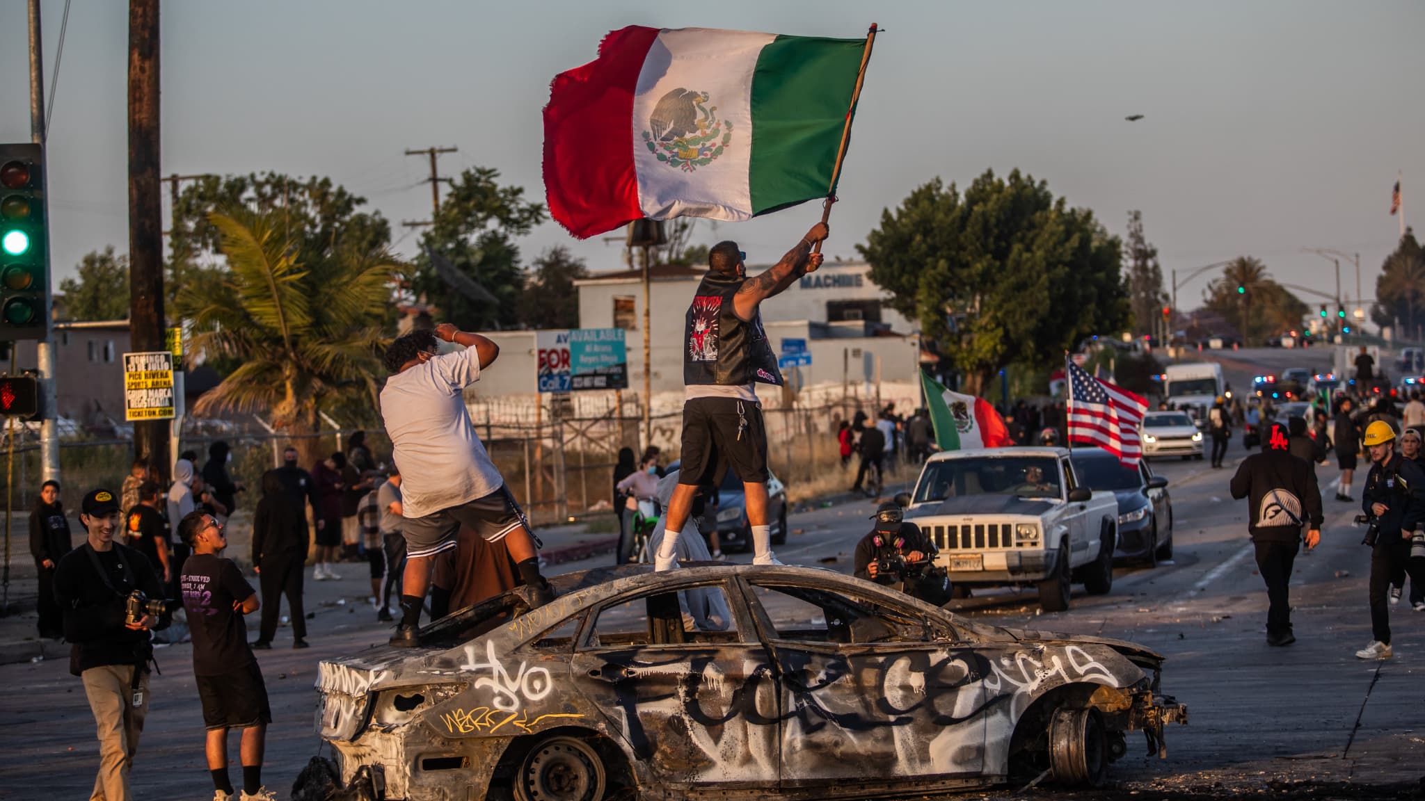 A protester is in a burned car while holding a Mexican flag in Atlantic Ave, on June 7, 2025 in Paramount, California. A protester is in a burned car while holding a Mexican flag in Atlantic Ave, on June 7, 2025 in Paramount, California.