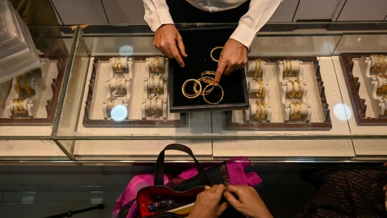 Un gérant de magasin en train de parler avec des clients dans une bijouterie, le 11 août 2021  