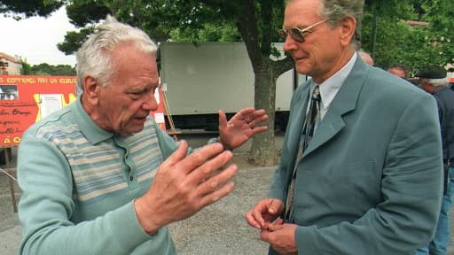 Le maire communiste de Gardanne, Roger Meï (d) discute avec un passant sur le marché de Bouc Bel Air près d'Aix-en-Provence, le 11 mai 1997