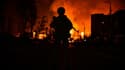 Un membre des forces spéciales ukrainiennes se tient devant l'incendie d'une station de gaz provoqué par des frappes russes à Kharkiv, dans l'est de l'Ukraine, le 30 mars 2022