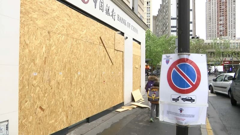 Une banque murée par des panneaux de bois place d'Italie
