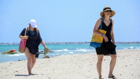 Des touristes européens marchent sur la plage d’un hôtel de l’île tunisienne de Djerba le 18 juillet 2020, au lendemain de l’arrivée des premiers vols charters vers le pays depuis l’éclatement de la crise du nouveau coronavirus